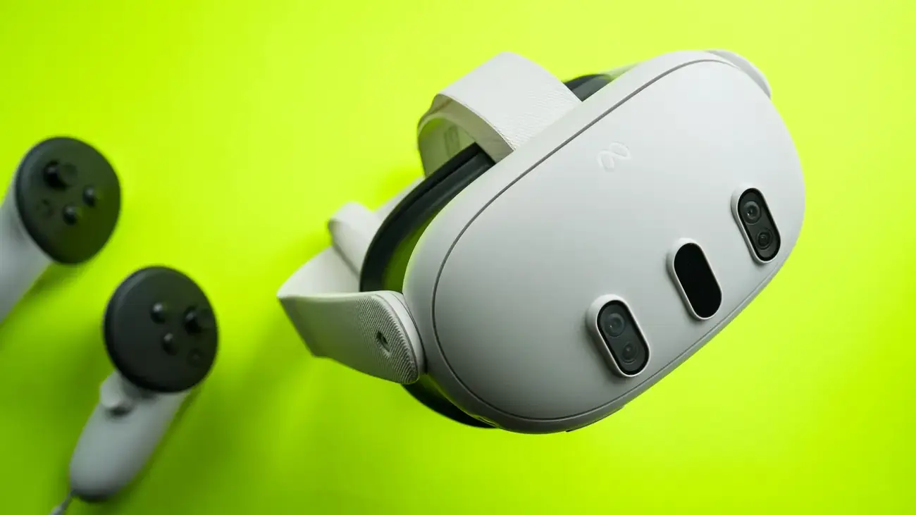 Vue en angle plongeant du casque de réalité virtuelle Meta Quest 3 et de ses deux manettes Touch Plus posés sur un fond vert vif.